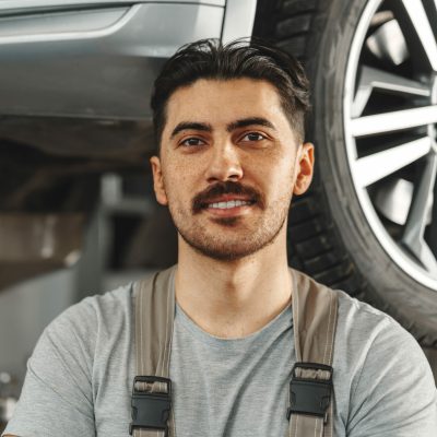 Portrait of a male mechanic in an auto repair shop close up